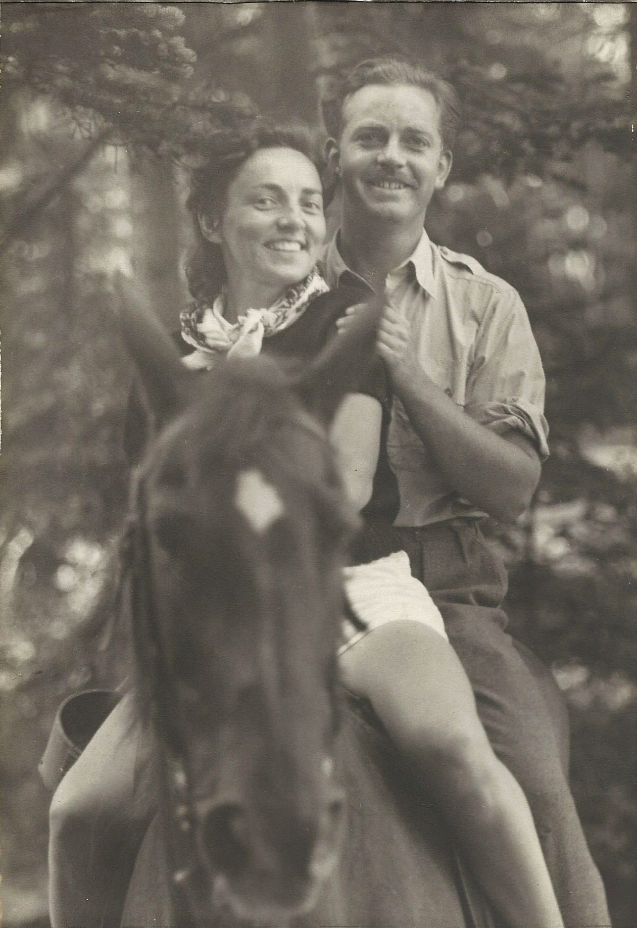 a man and woman sitting on a horse